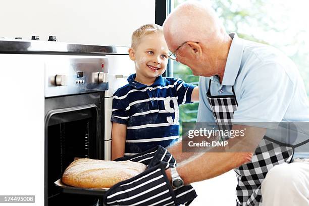 grandfather and grandson making bread - baking bread stock pictures, royalty-free photos & images