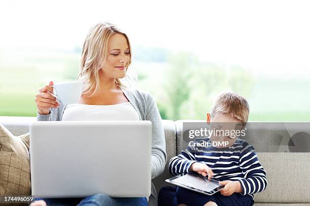 happy mother and son using computers - mother and son using tablet and laptop stock pictures, royalty-free photos & images