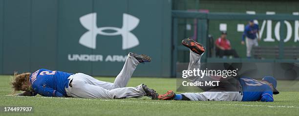 New York Mets first baseman Justin Turner and right fielder Andrew Brown lie on the ground after colliding while going after a ball hit to short left...