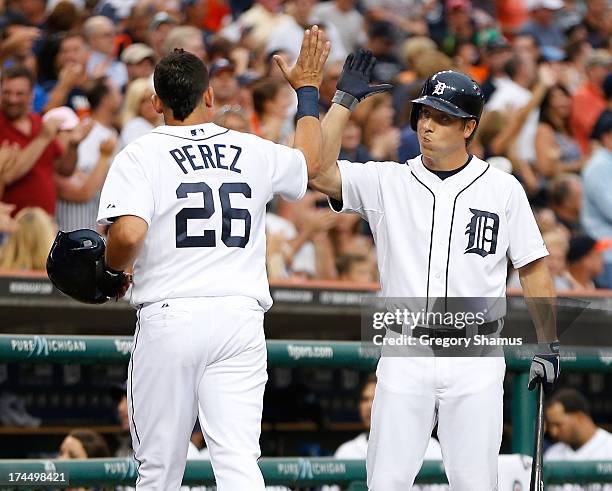 Hernan Perez of the Detroit Tigers celebrates scoring a fifth inning run with Andy Dirks while playing the Philadelphia Phillies at Comerica Park on...