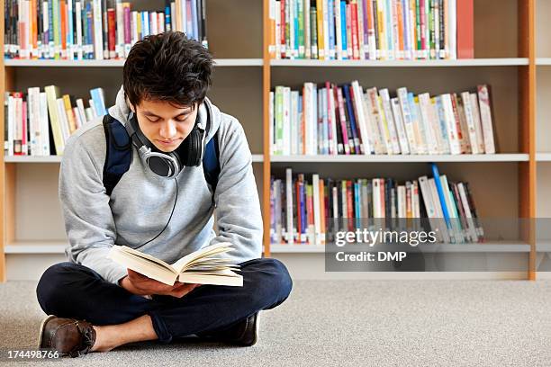teenager reading a book in the library - teenager reading stock pictures, royalty-free photos & images