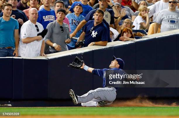 Sam Fuld of the Tampa Bay Rays attempts to make a catch on a fifth-inning foul ball off the bat of Robinson Cano of the New York Yankees at Yankee...