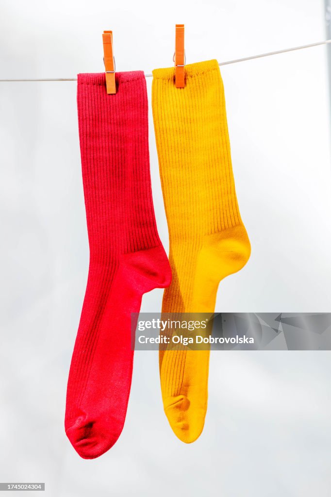 Pair of colourful socks drying on a clothesline outdoors