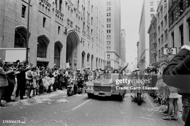 Apollo 10 astronauts Gene Cernan, Tom Stafford, and John Young, with San Francisco Mayor Joseph Alioto, wave from a convertible limousine during a...