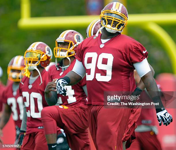 Washington's defensive end Jarvis Jenkins , right, warms up during the Washington Redskins afternoon practice on day 1 of summer training camp at the...
