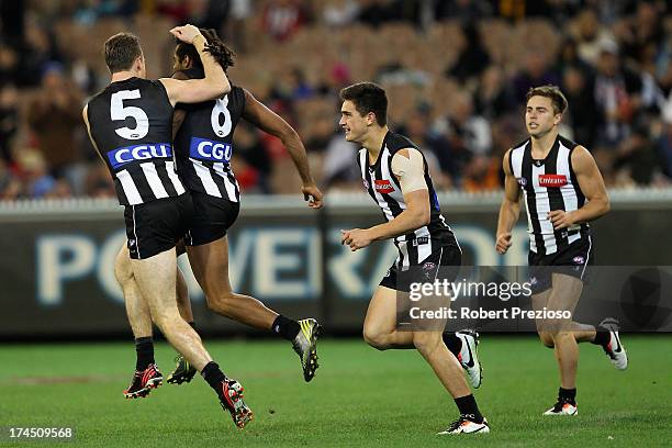 Harry O'Brien of the Magpies celebrates kicking a goal with team-mate Nick Maxwell of the Magpies during the round 18 AFL match between the...