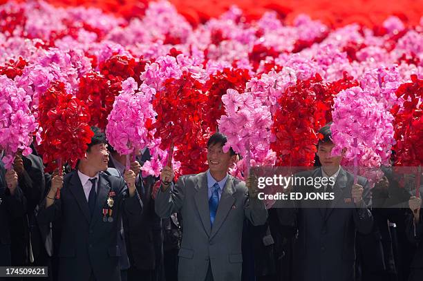 North Korean participants wave flowers during a parade marking the 60th anniversary of the Korean war armistice in Pyongyang on July 27, 2013. North...