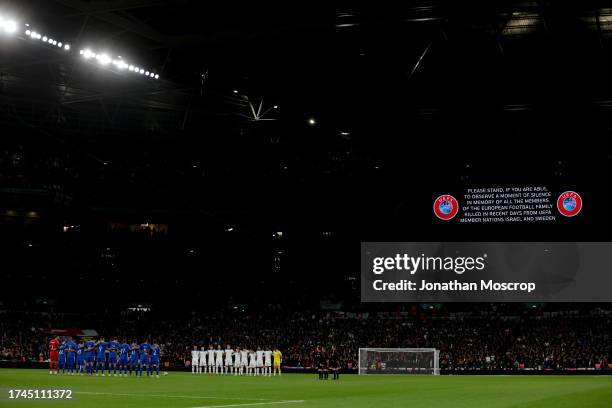 The two teams and officials line up as a message from UEFA is displayed on the stadium screen to announce a minute's silence for the recent victims...