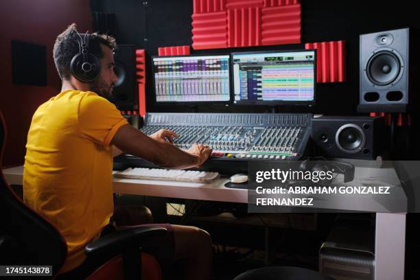 tecnico del suono che lavora seduto davanti al tavolo di missaggio del suono. - musica di produzione foto e immagini stock