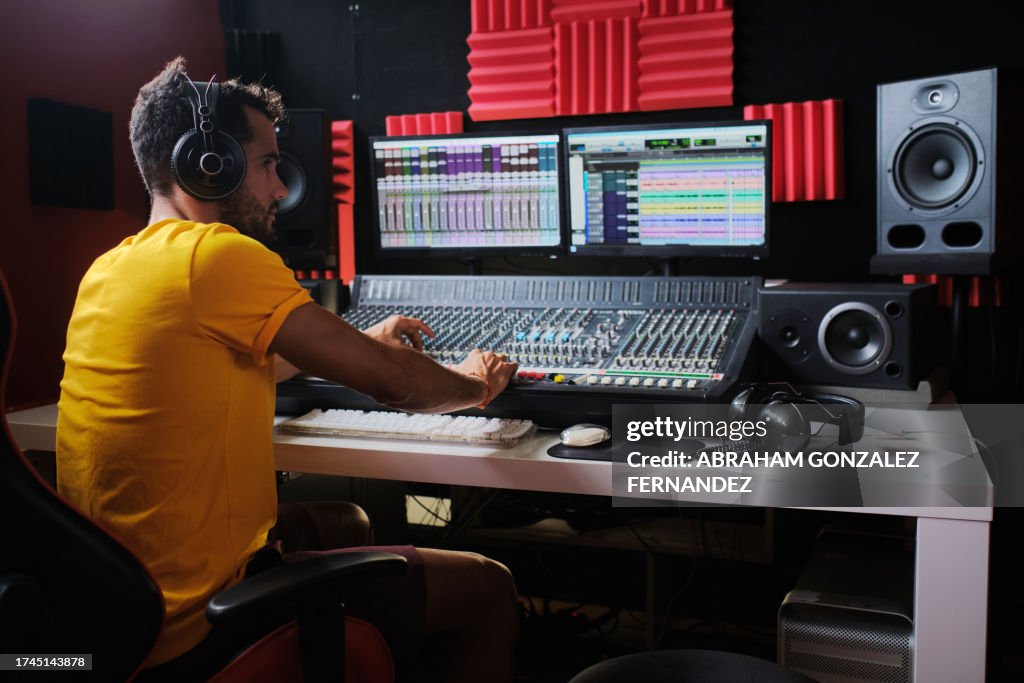 Sound technician working sitting in front of the sound mixing table.