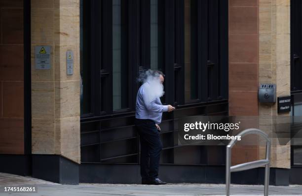 An office worker smokes a vape outside a building in London, UK, on Wednesday, Oct. 25, 2023. British workers coming into the office every day...