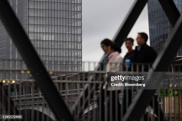 City workers pass a tower with empty office floors, left, in London, UK, on Wednesday, Oct. 25, 2023. British workers coming into the office every...