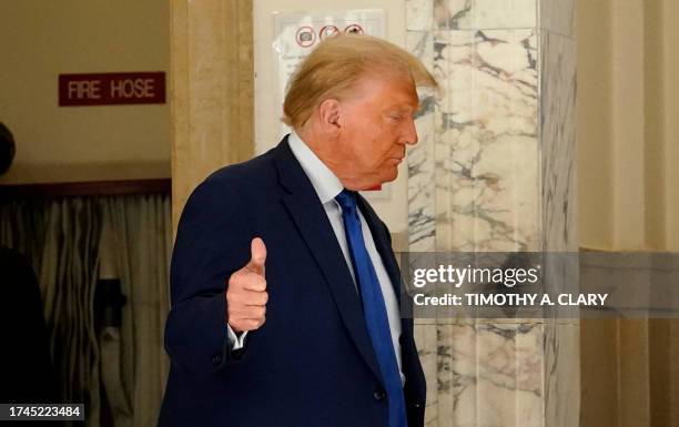 Former US president Donald Trump gives a thumbs up during a break at court in New York at his $250 million civil fraud trial against him and his...