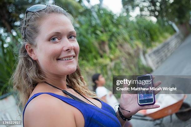 a woman shows a photo taken from her phone - livingston guatemala stock pictures, royalty-free photos & images