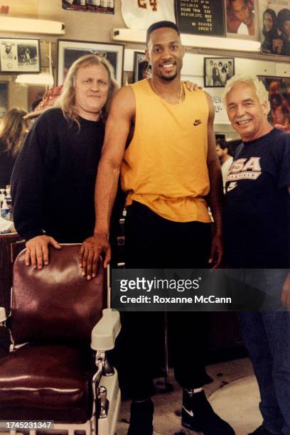 Joe Pytka, Alonzo Mourning of the Charlotte Hornets and Austin McCann take a break on the set of the Nike "Barbershop" commercial in 1994 in San...