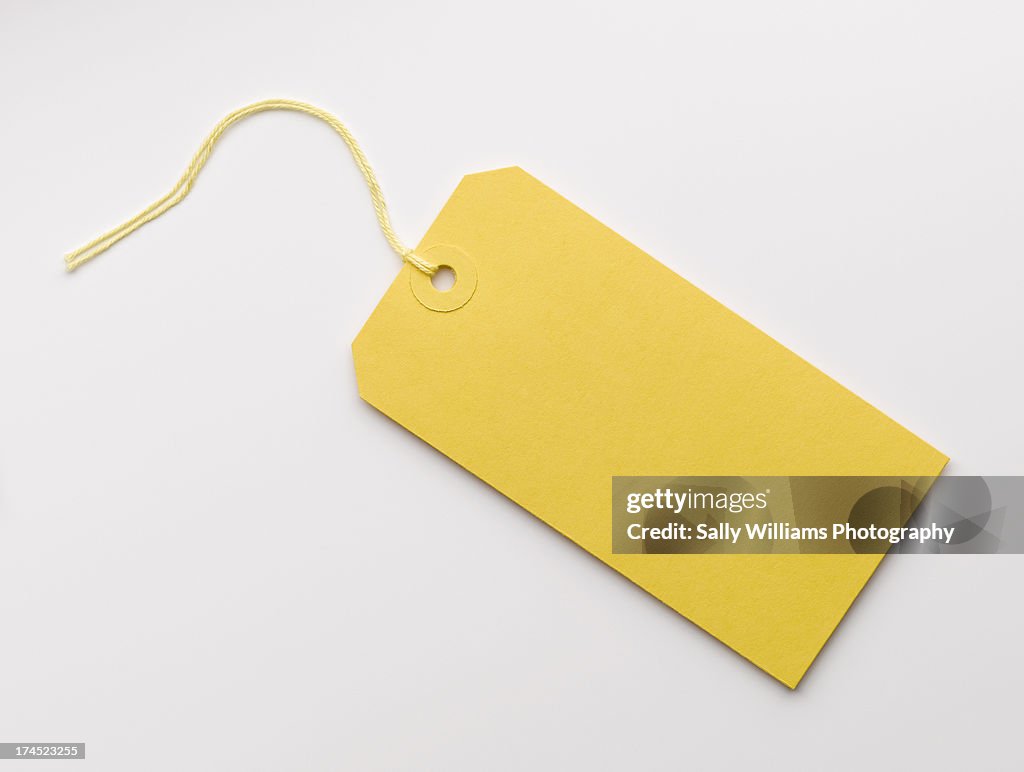 A yellow luggage tag on a white background