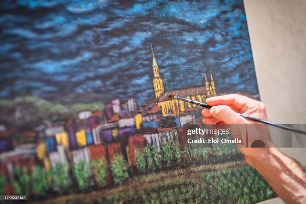 Artist painter paiting a city on canvas