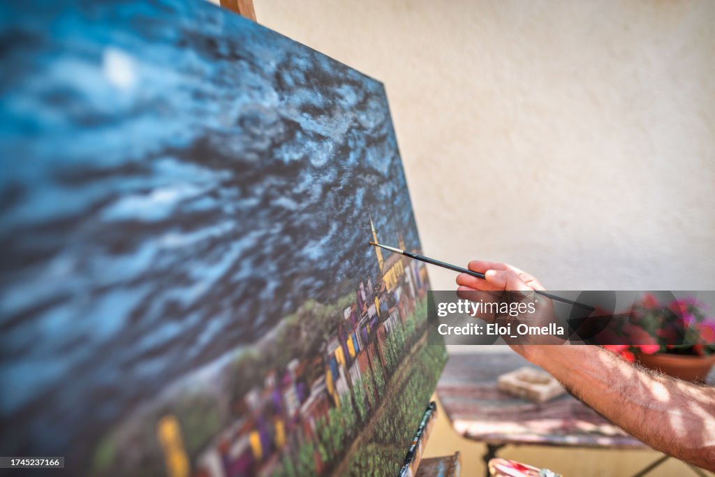 Artist painter paiting a city on canvas