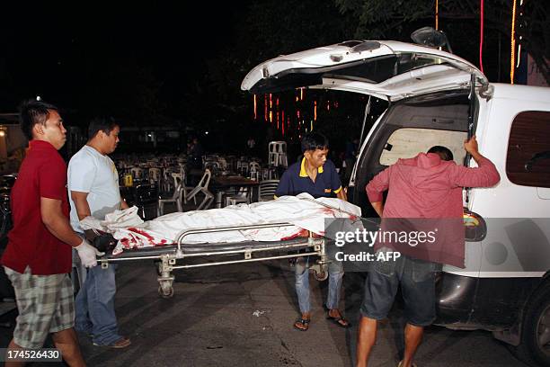 Funeral parlor workers carry a stretcher with a dead body into a vehicle after an improvised explosive device went off at a popular restaurant in...