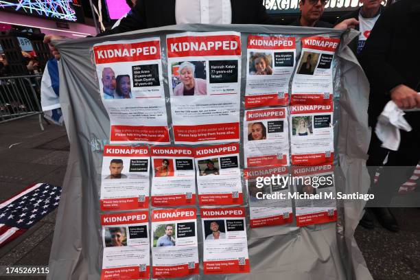 Man holds a banner displaying photos of kidnapped Israelis at a rally in Times Square demanding Hamas free Israeli hostages on October 19, 2023 in...