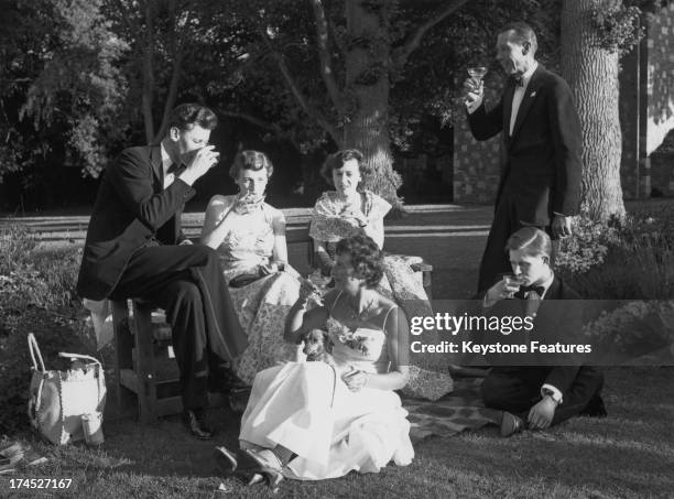 Opera goers enjoy the evening sunshine in the gardens of Glyndebourne, during the interval of the 'The Marriage of Figaro', Sussex, 1955.