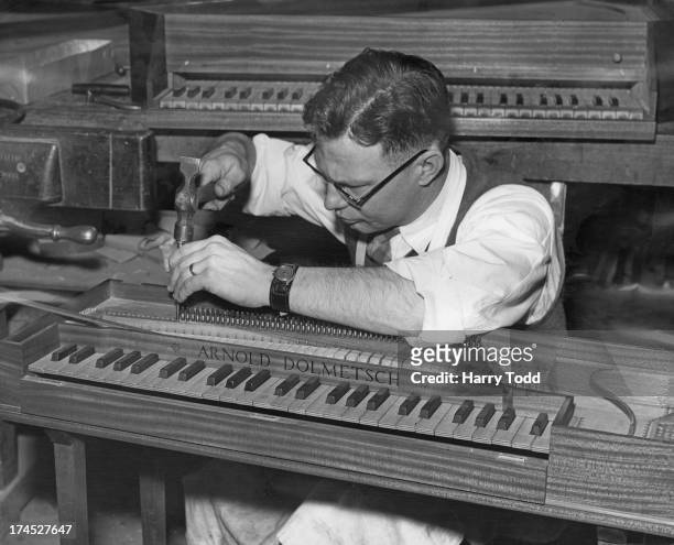 Olin Tillotson strings a small portable Gebunden clavichord at the Arnold Dolmetsch Workshop, Haslemere, Surrey, 18th January 1957. The workshop...