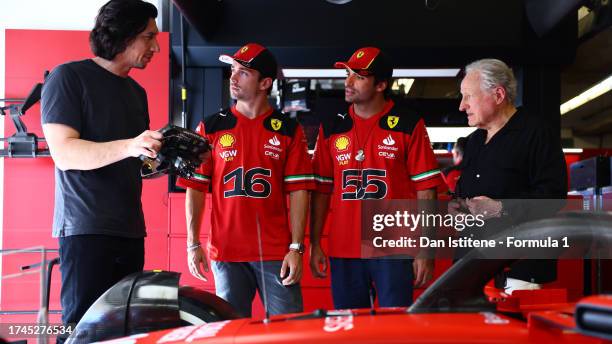 Charles Leclerc of Monaco and Ferrari and Carlos Sainz of Spain and Ferrari give Adam Driver and Michael Mann a tour of the Ferrari garage during...