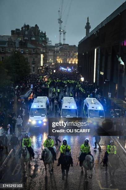 Police officers lead Borussia Dortmund's fans towards St James' Park in Newcastle-upon-Tyne, north east England, on October 25, 2023 ahead of the...