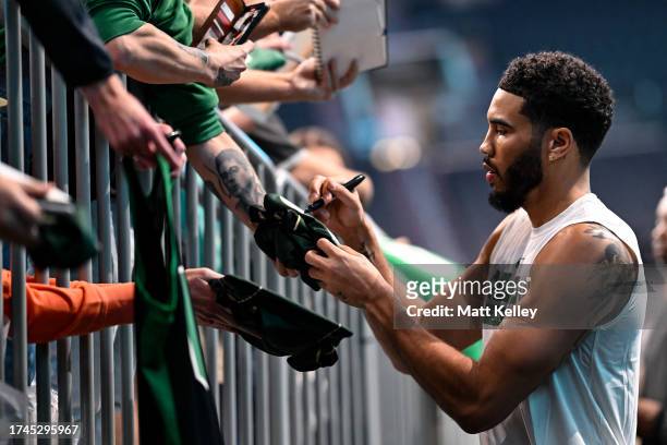 Jayson Tatum of the Boston Celtics signs autographs prior to the preseason game against the Charlotte Hornets at Spectrum Center on October 19, 2023...