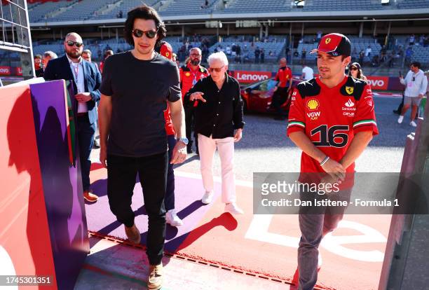 Carlos Sainz of Spain and Ferrari and Charles Leclerc of Monaco and Ferrari talk with Michael Mann and Adam Driver in the Paddock during previews...