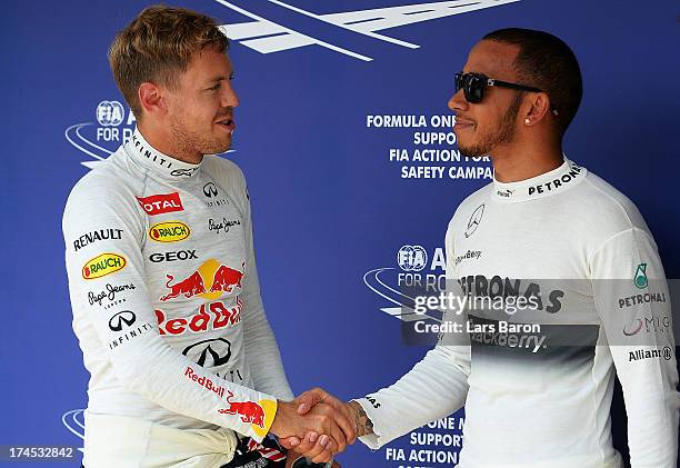 Polesitter Lewis Hamilton of Great Britain and Mercedes GP celebrates with second placed Sebastian Vettel of Germany and Infiniti Red Bull Racing...