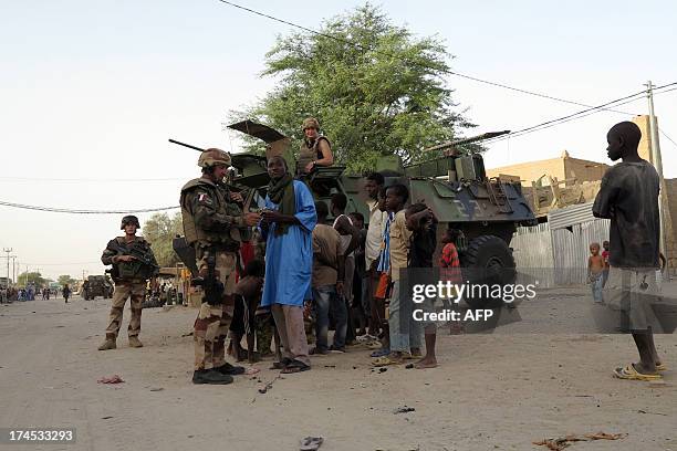 Children speak with French soldiers part of the Serval operation on July 25, 2013 in a street of Timbuktu. Millions of Malians are expected to vote...