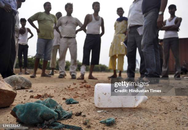 Bottle of acid and burnt clothes of the acid-attack victim lying near the incident spot at Crossings-Republik area of Ghaziabad on July 26, 2013 in...