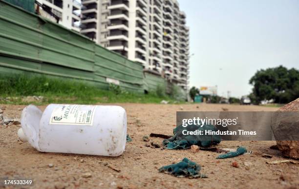 Bottle of acid and burnt clothes of the acid-attack victim lying near the incident spot at Crossings-Republik area of Ghaziabad on July 26, 2013 in...