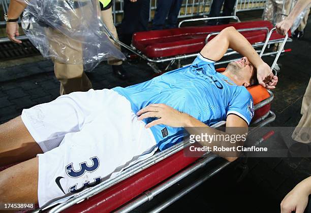 Matija Nastasic of Mancester City is taken from the ground with an injury during the Barclays Asia Trophy Final match between Manchester City and...