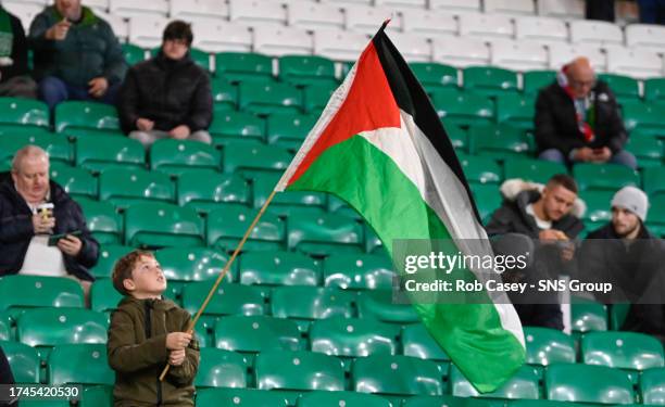 Young fan holds a Palestine flag during a UEFA Champions League match between Celtic and Atletico de Madrid at Celtic Park, on October 25 in Glasgow,...