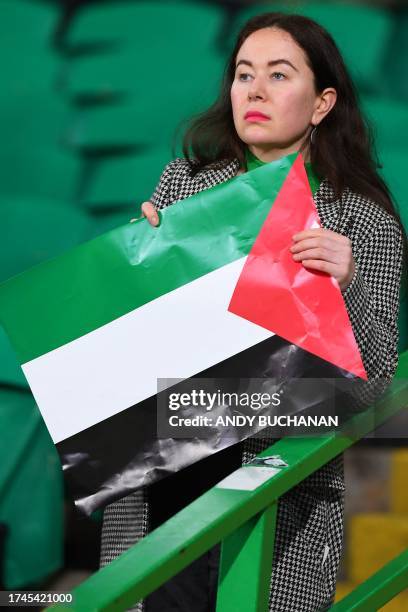 Supporter holds a Palestinian flag prior to the start of the UEFA Champions League group E football match between Celtic and Atletico Madrid at...