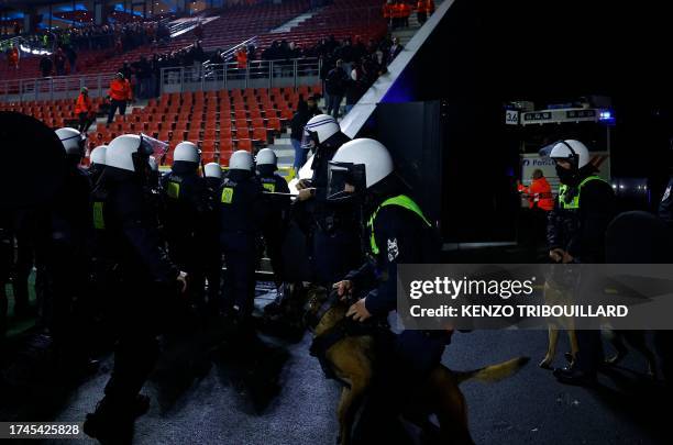 Security personnel arrive with dogs as Antwerp supporters gather in the stands after the UEFA Champions League Group H football match between Antwerp...
