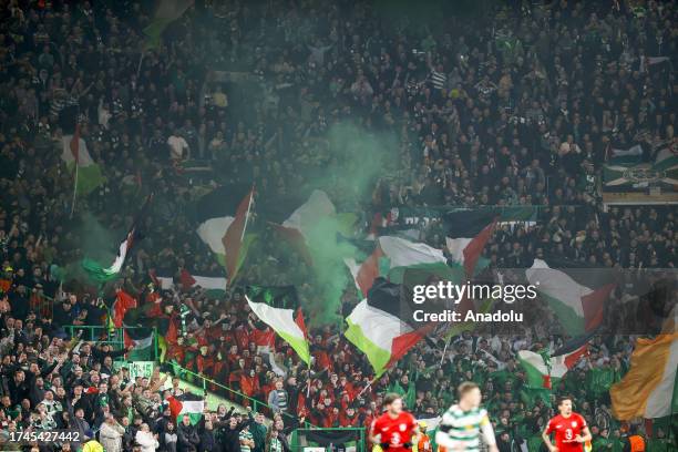 Supporters hold Palestinian flags as they cheer prior to the start of the UEFA Champions League group E football match between Celtic and Atletico...