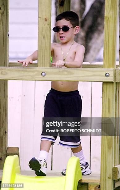 Six-year-old Elian Gonzales plays in the backyard of his Miami relatives home 04 April, 2000. Government officials are currently meeting with Elian's...