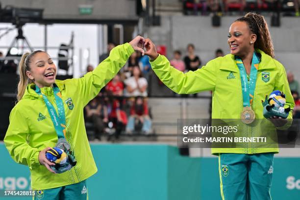 Brazil's Flavia Saraiva and Brazil's Rebeca Andrade celebrate on the podium with their silver and gold medals respectively, after the artistic...