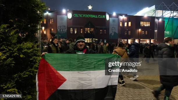 Supporters hold Palestinian flags at the end of the UEFA Champions League group E football match between Celtic and Atletico Madrid at Celtic Park...