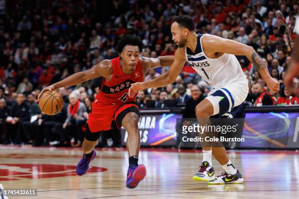 Scottie Barnes of the Toronto Raptors dribbles the ball against Kyle Anderson of the Minnesota Timberwolves during the second half of their NBA game...