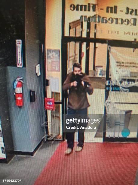 Man with a gun walks on the street after shoot civil in Maine, United States on October 26, 2023. At least 22 people were killed in shootings at...