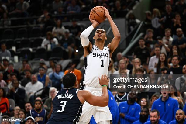 San Antonio Spurs' French forward-center Victor Wembanyama shoots the ball past Dallas Mavericks' US power forward Grant Williams during the NBA...