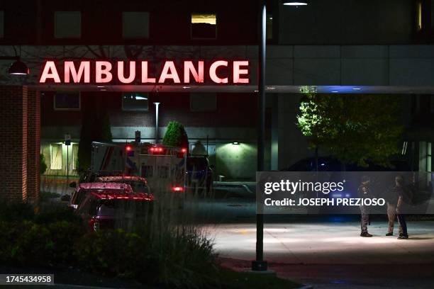 Law enforcement officials guard the ambulance entrance to the Central Maine Medical Center in Lewiston, Maine early on October 26, 2023. A massive...