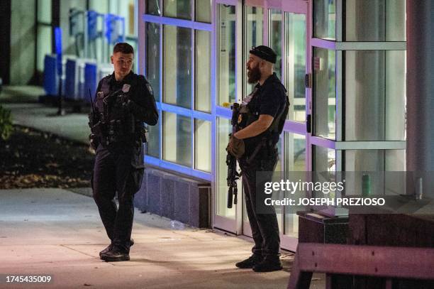 Armed law enforcement officials guard the ambulance entrance to the Central Maine Medical Center in Lewiston, Maine early on October 26, 2023. A...