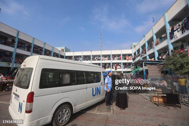 Man speaks with a worker of the United Nations Relief and Works Agency for Palestine Refugees agency outside one of their vehicles parked in the...