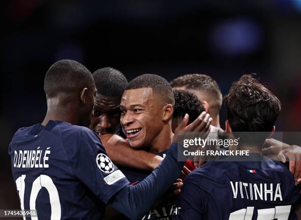 Paris Saint-Germain's French forward Kylian Mbappe celebrates with teammates after scoring his team's first goal during the UEFA Champions League...