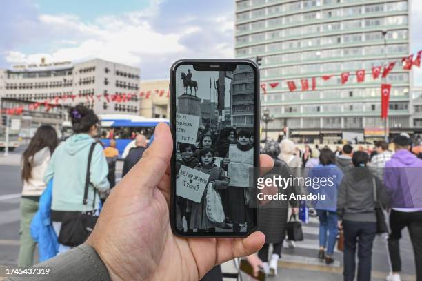 Man holds a phone showing Anadolu Agency's archive photo from 1989 of primary school students carrying out a clean-up campaign in Ulus, ahead of...